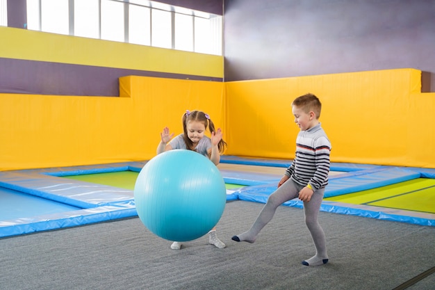 Gelukkig lachend kleine kinderen springen op binnenshuis trampoline in entertainment center