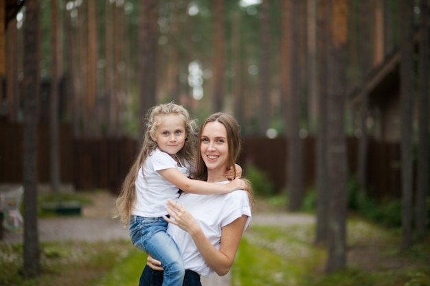 Gelukkig lachend moeder en schattig emotioneel dochtertje knuffelen