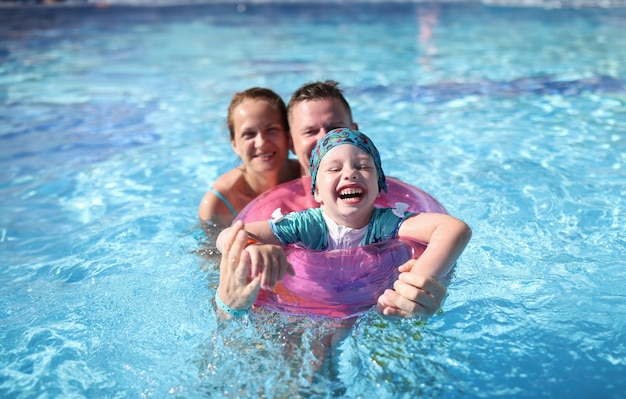 Gelukkig lachend vrolijk familiepaar en baby in zwembad Familievakantie met kinderen in waterpark