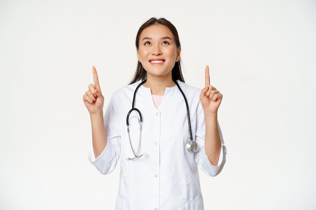 Gelukkig lachende arts aziatische vrouw arts opzoeken met vrolijke gezichtsuitdrukking dragen van medische ...