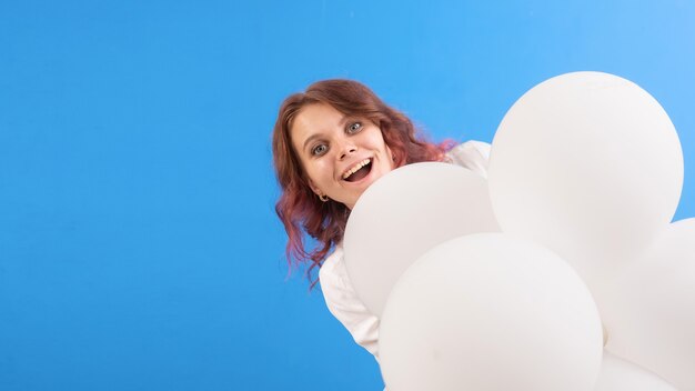 Gelukkig lachende blanke vrouw met witte ballonnen