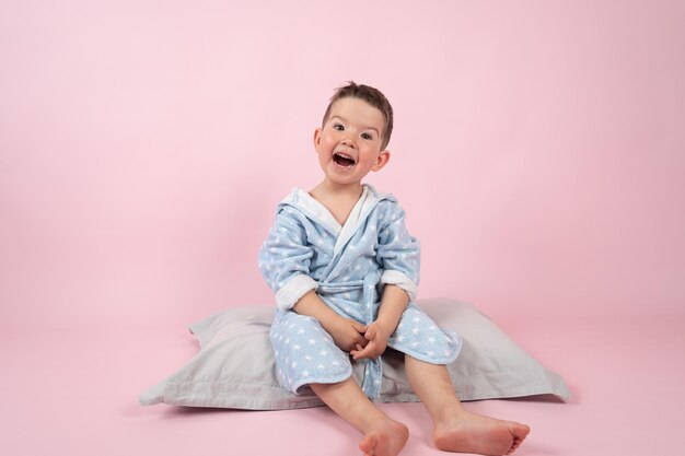 Gelukkig lachende jongen zittend op een kussen full-length portret Hoge kwaliteit foto