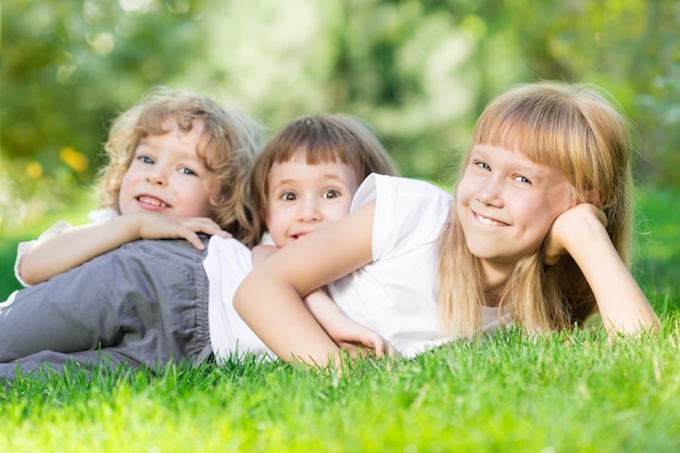 Gelukkig lachende kinderen spelen op groen gras in het voorjaarspark