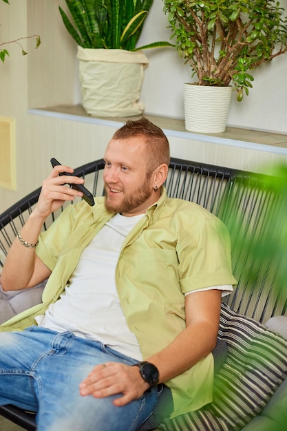 Gelukkig lachende man met mobiele telefoon praten met vrienden of familie met behulp van luidspreker