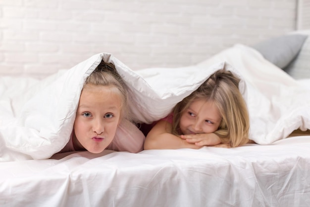 Gelukkig lachende ochtendkinderen in bed