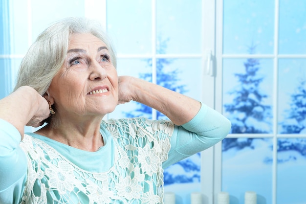 Gelukkig lachende senior vrouw die zich voordeed op Kerstmis