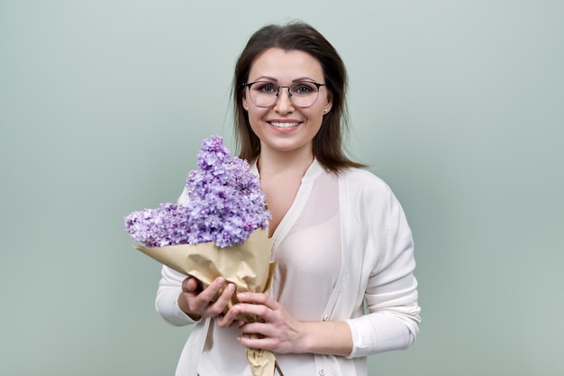 Gelukkig lachende volwassen vrouw met boeket bloemen