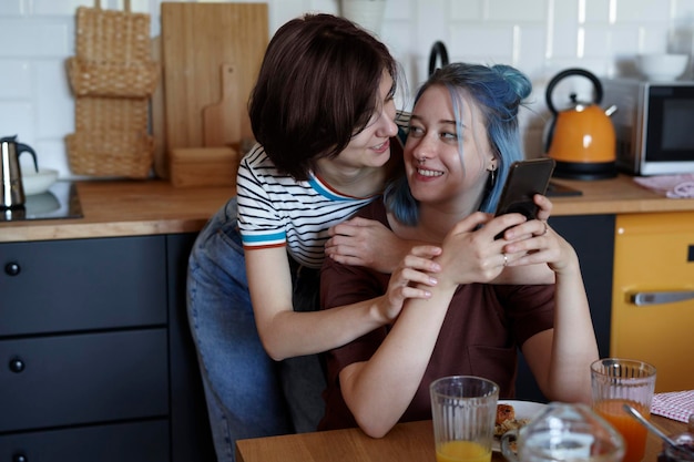 Gelukkig lesbisch koppel knuffelen tijdens het ontbijt.