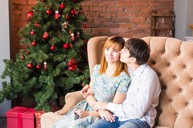 Gelukkig liefdevol paar in de buurt van de kerstboom.