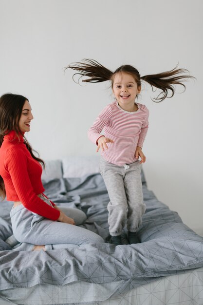 Gelukkig liefdevolle familie. Moeder en haar en dochterkindmeisje die spelen koesteren.