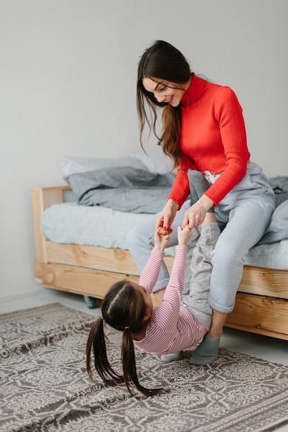 Gelukkig liefdevolle familie. Moeder en haar en dochterkindmeisje die spelen koesteren.