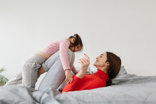 Gelukkig liefdevolle familie. moeder en haar en dochterkindmeisje die spelen koesteren.