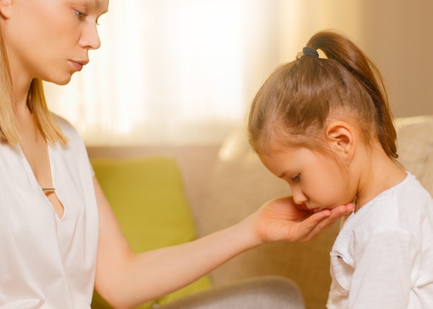 Gelukkig liefdevolle familie. Mooie moeder troost zijn jonge gefrustreerde dochter.