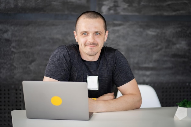 Gelukkig man aan het werk op laptop in bibliotheek of coworking kantoorruimte