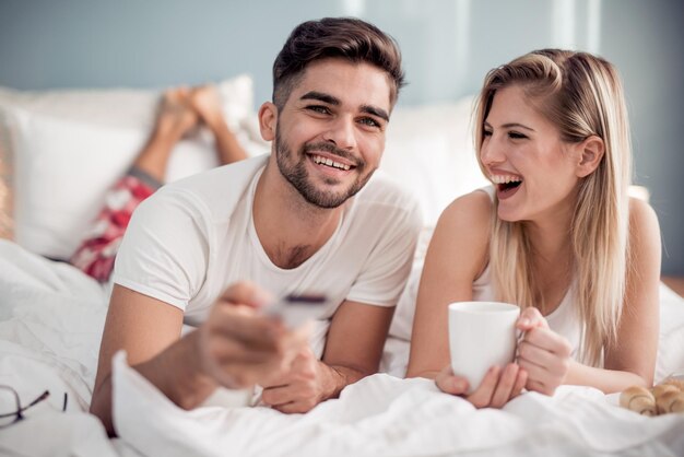 Gelukkig man en vrouw ontbijten op bed