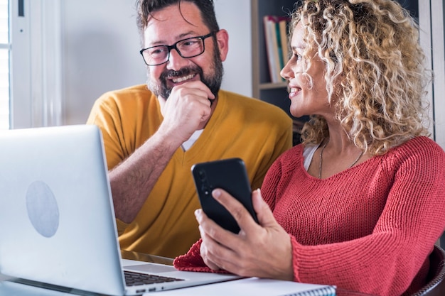 Foto gelukkig man en vrouw paar werken thuis in slim werkende kantooractiviteit samen met vreugde - digitale moderne volwassen mensen in online internet baanactiviteit - vrolijke vrouw en man met behulp van computer