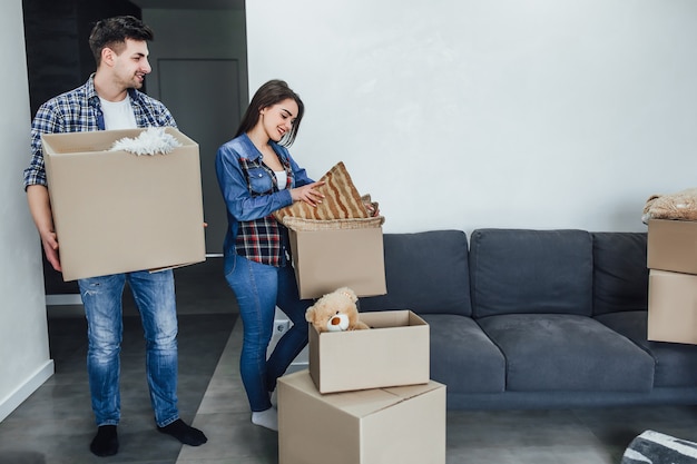 Gelukkig man en vrouw uitpakken spullen uit cartoon dozen tijdens het interieur