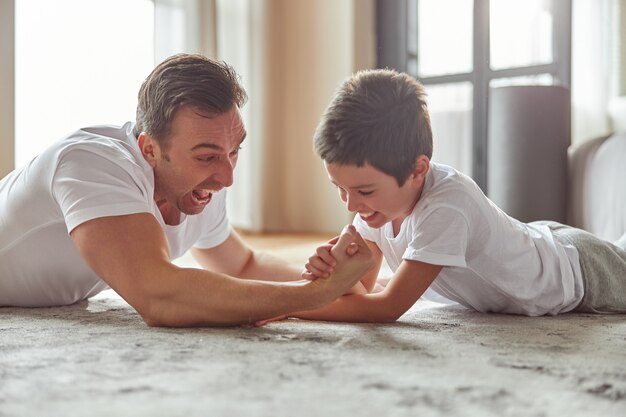 Gelukkig man genieten van actieve tijd met zoon binnenshuis