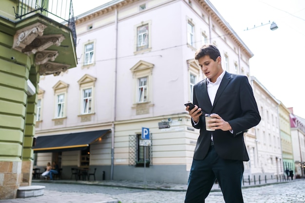 Gelukkig man in een pak en shirt glimlachend praten aan de telefoon op th