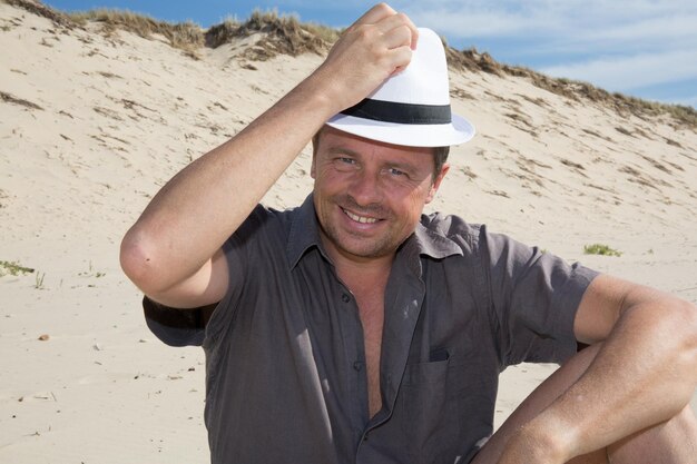 Gelukkig man lachen en ontspannen op het strand