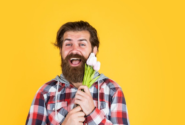 Gelukkig man met baard houden tulp bloemen vaders dag concept gelukkige verjaardag cadeau lente boeket voor haar klaar voor romantische datum aanwezig voor vrouwendag vieren moederdag