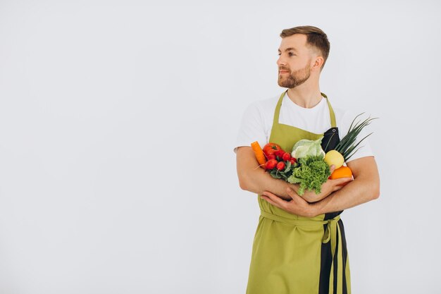 Gelukkig man met veel verschillende verse groenten op witte achtergrond