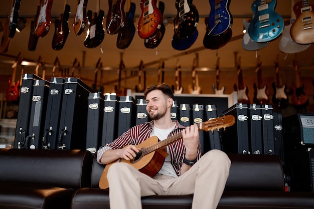 Gelukkig man muzikant gitaar spelen over snaarinstrument winkel winkel achtergrond