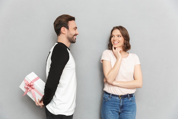 Gelukkig man staande geïsoleerd bedrijf huidige geschenkdoos voor zijn vrouw.