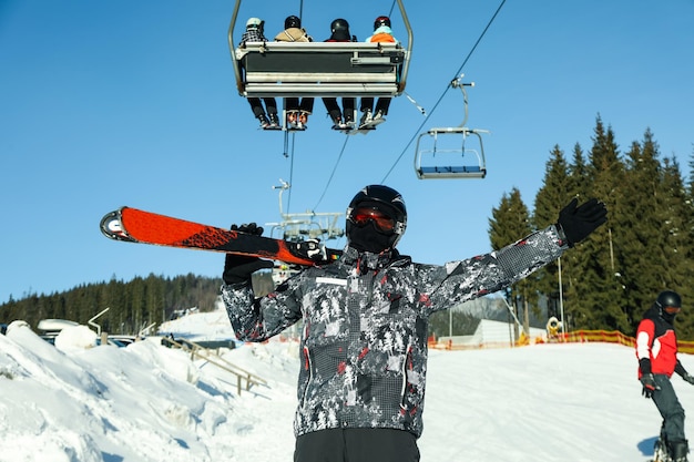 Gelukkig mannelijke skiër in bergresort in zonnige dag