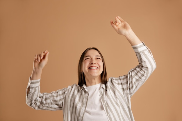 gelukkig meisje dansen op beige achtergrond genieten van het leven en energie