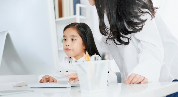 Gelukkig meisje dat computer met haar moeder bekijkt