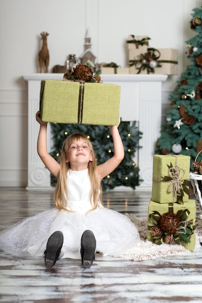 Gelukkig meisje dat een grote doos met een gift over haar hoofd houdt. wintervakantie, kerstmis en mensenconcept