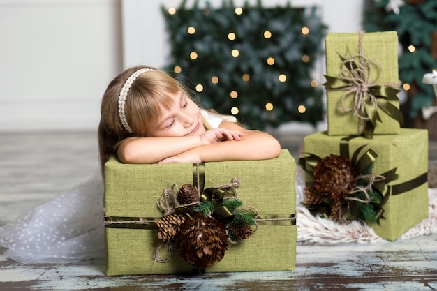 Gelukkig meisje dat een grote doos met een gift over haar hoofd houdt.