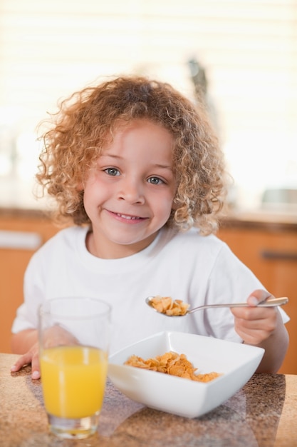 Gelukkig meisje die graangewassen voor ontbijt eten