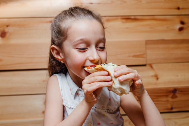 Gelukkig meisje eet vegetarische wrap ijsberg