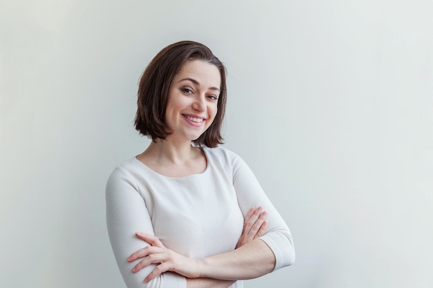 Gelukkig meisje glimlachen. Schoonheid portret jonge gelukkig positief lachen brunette vrouw op wit geïsoleerd