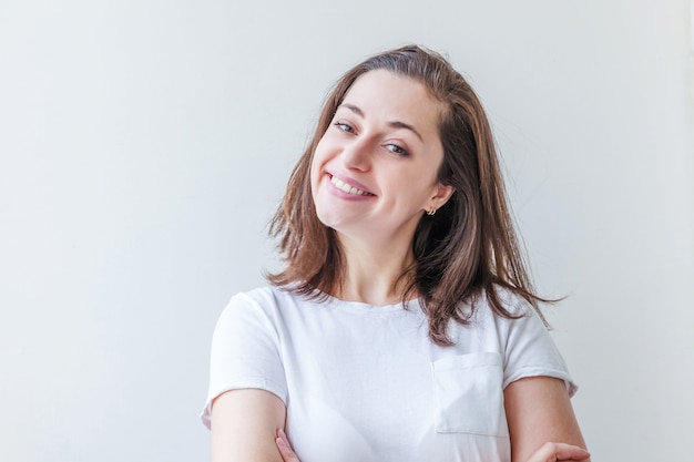 Gelukkig meisje glimlachen. Schoonheid portret jonge gelukkig positieve brunette vrouw geïsoleerd op een witte achtergrond.