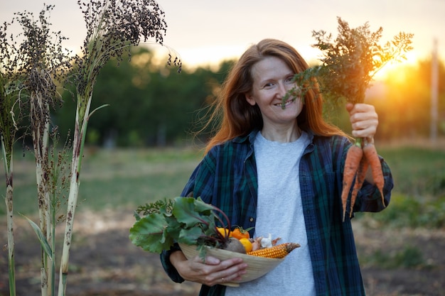 Gelukkig meisje houdt een schaal met groenten uit je tuin