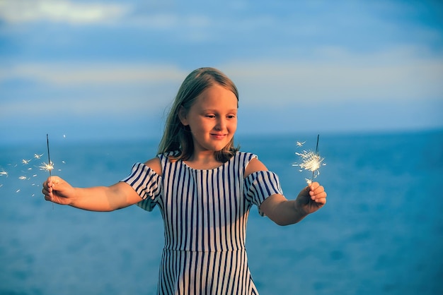 gelukkig meisje in een jurk tijdens een vakantie met sterretjes in haar handen aan de kust