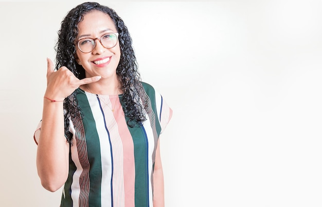 Gelukkig meisje in glazen gebaren bel me met geïsoleerde hand Latijnse vrouw in glazen gebaren gesprek met geïsoleerde vingers