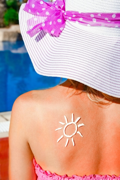 Gelukkig meisje met de zon op haar rug bij het zwembad in de natuur