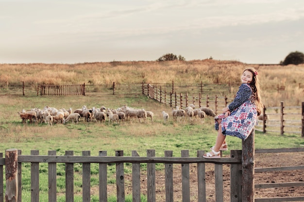 Gelukkig meisje met schapen op boerderij