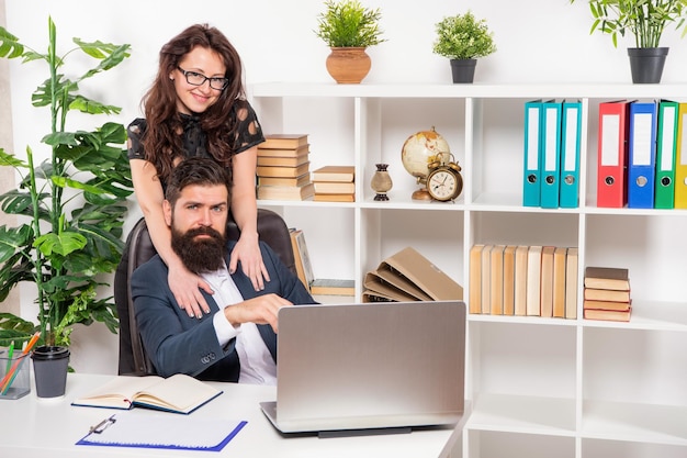 Gelukkig meisje omarmen man aan het werk op laptop op workpalce kantoor romantiek