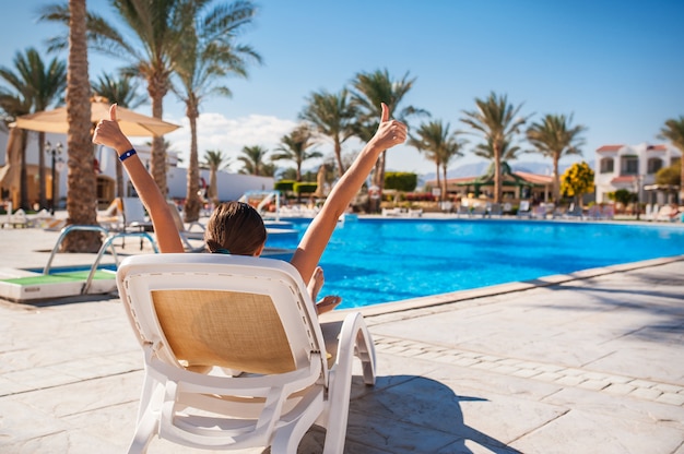 Gelukkig meisje op een ligstoel in de zomer, op vakantie