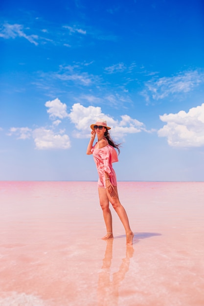 Gelukkig meisje op een roze zoutmeer op een zonnige de zomerdag. De natuur verkennen, reizen, familievakantie.