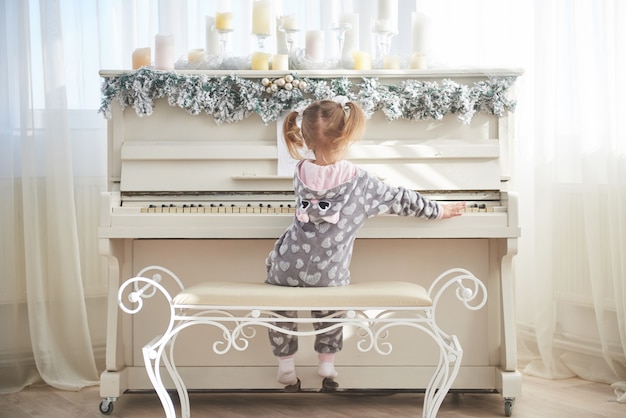 Gelukkig meisje piano spelen op eerste kerstdag