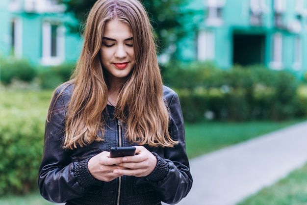 Gelukkig meisje sms'en op een slimme telefoon