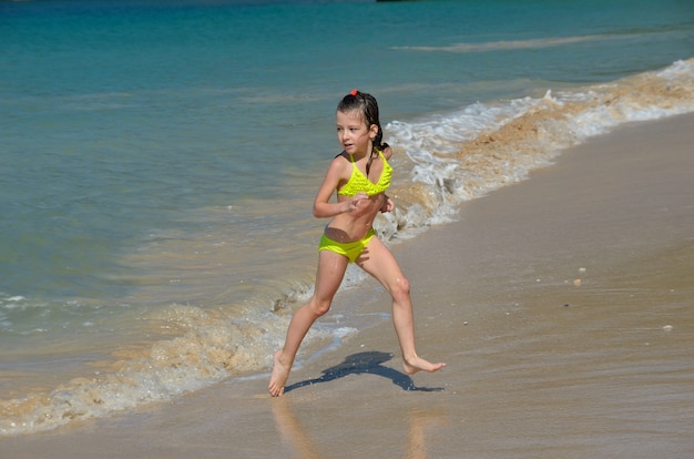 Gelukkig meisje speelt in zee op tropisch strand,