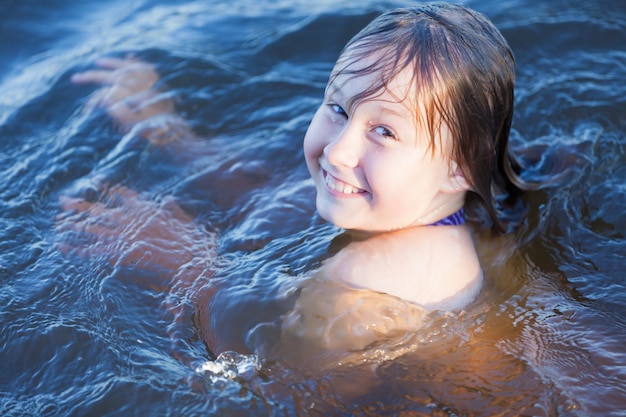 Gelukkig meisje zwemt in het water