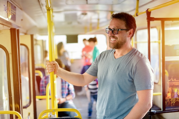 Gelukkig middelbare leeftijd man bedrijf voor een bar in een bus en lachend. Wachten tot de bus verder rijdt.